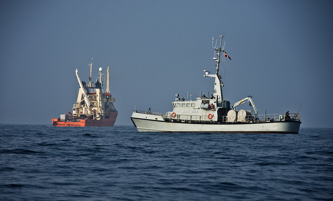 Et af Marinehjemmeværnets fartøjer ses sammen med et af Forsvarets miljøskibe