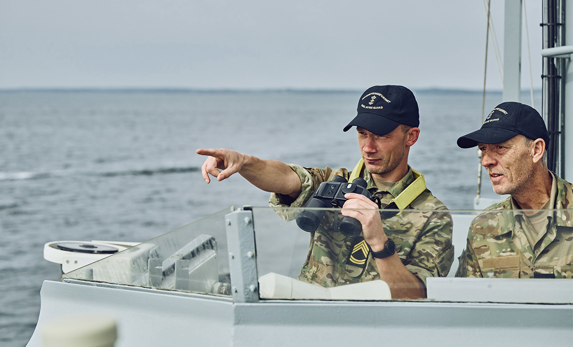 Soldater på et Marinehjemmeværnets fartøjer spejder ud over havet.