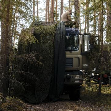 Soldat sidder på lastbil.